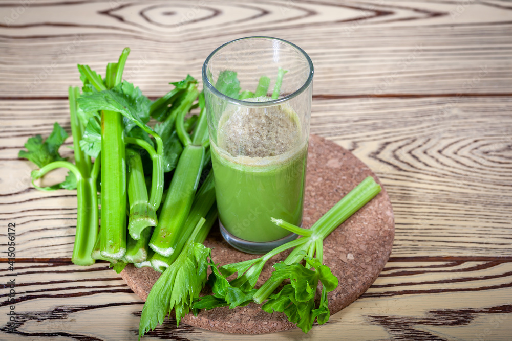 Healthy Celery diet for the treatment of incurable mysterious diseases. Fresh celery juice squeezed out on a juicer.drink, vegetable juice, studio shot Healthy Celery diet for the treatment of incurable mysterious diseases. Fresh celery juice squeezed out on a juicer.drink, vegetable juice, studio shot