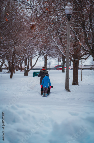parent and child walking in the snow © sabinoalonsostudio