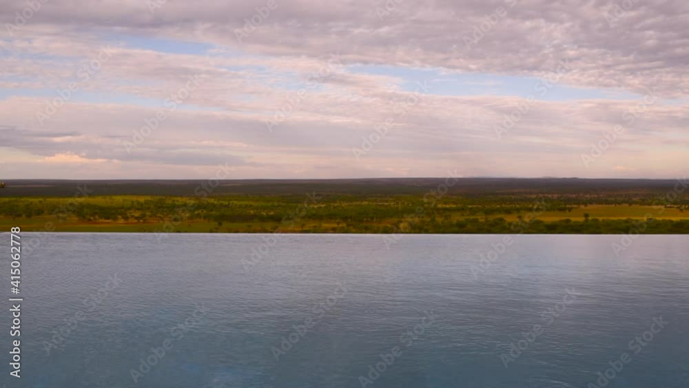 Man jumping into infinity pool of resort in Serengeti, Tanzania. Static Man jumping into infinity pool of resort in Serengeti, Tanzania. Static