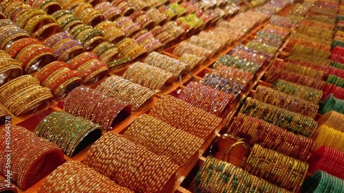 Indian traditional colourful women's glass bangles on display decorated for sale  during christmas fair at night. Bangles shining on lights photo