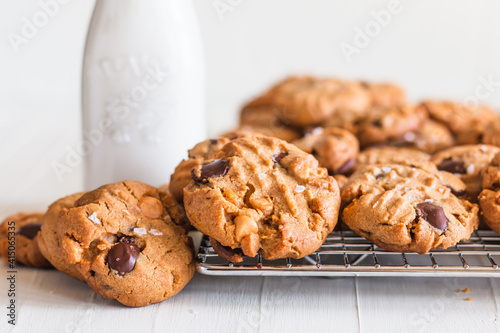 Konstfotografi Fresh baked cookies on a cooling rack near bottled milk