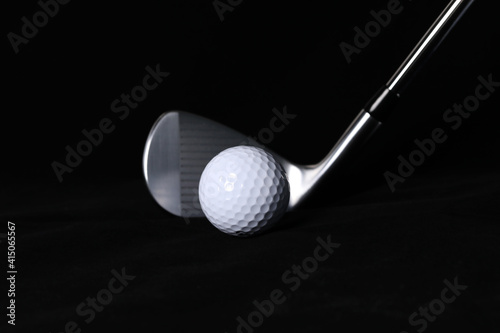 Black background, golf balls and clubs.