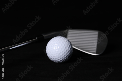 Black background, golf balls and clubs.