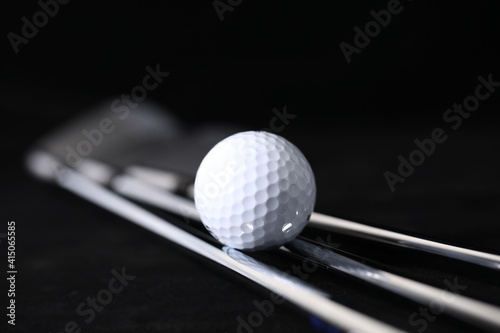 Black background, golf balls and clubs.
