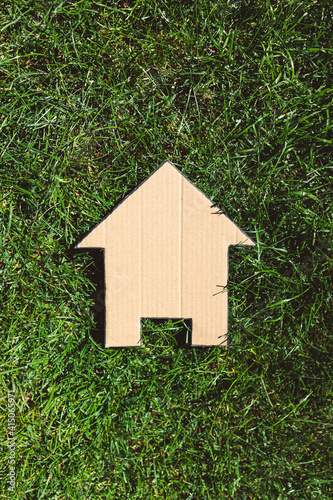 green home and eco-friendly construction, house icon on green grass lawn under the sun photo