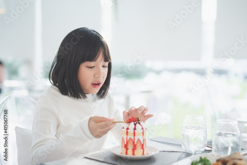 Beautiful Asian girl eating shortcake in a cafe