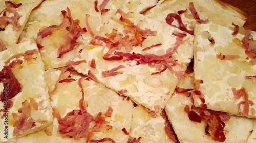 Tarte Flambee is a kind of French pizza from Alsace made from a very thin layer of pastry topped with sour cream, chopped onions and bacon photo