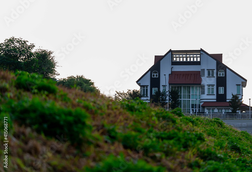 Modern house on a valley or hill covered with grass and trees