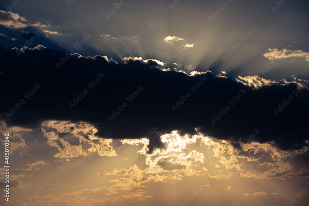 Sunset, sunlight behind the clouds