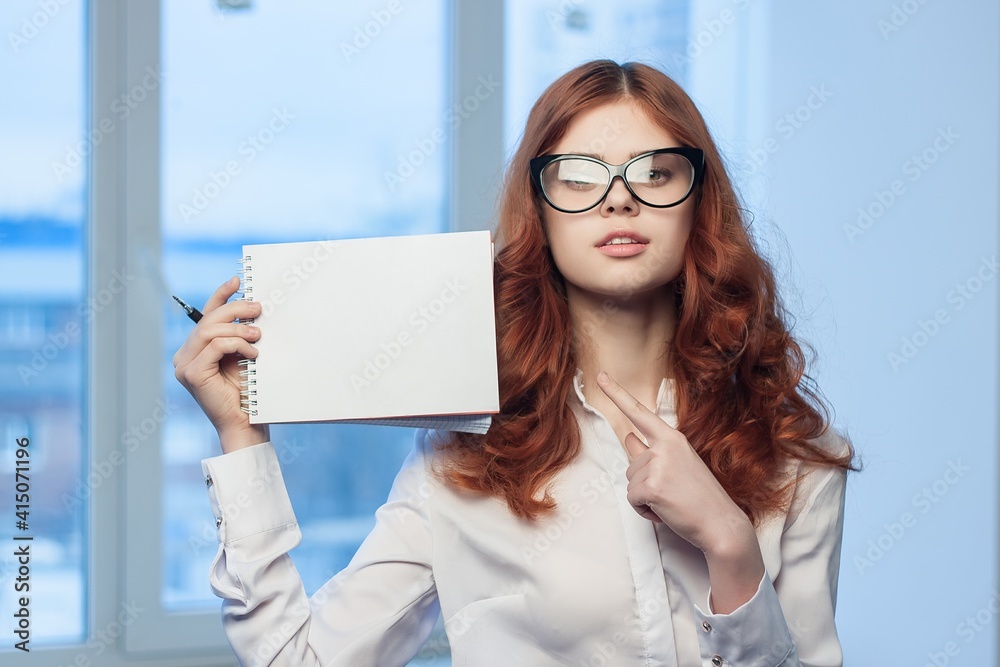 Business red-haired woman holding notepad in the hands of an official manager Business red-haired woman holding notepad in the hands of an official manager