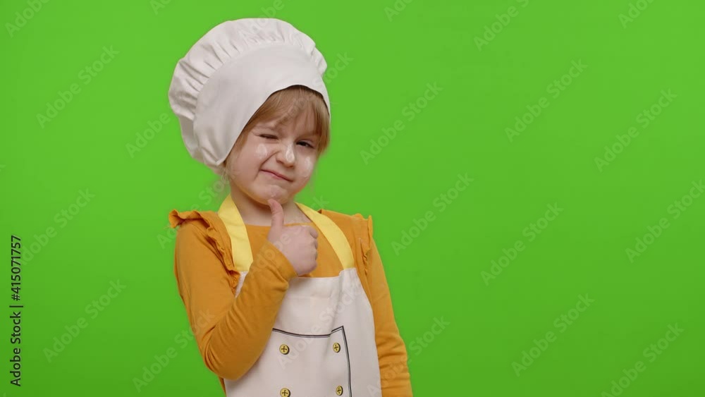 Funny Caucasian preschooler child girl dressed cook chef baker in apron and hat showing thumbs up, fooling around isolated on chroma key background. Slow motion. Cooking school, children education Funny Caucasian preschooler child girl dressed cook chef baker in apron and hat showing thumbs up, fooling around isolated on chroma key background. Slow motion. Cooking school, children education