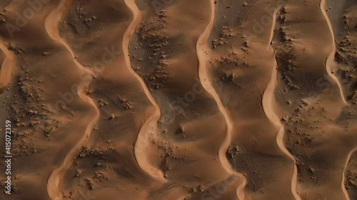 UAE DESERT: Drone flying over breathtaking massive golden sand dunes during sunset, Top-down view of the United Arab Emirates's Wild desert. 4k 60FPS Foot photo