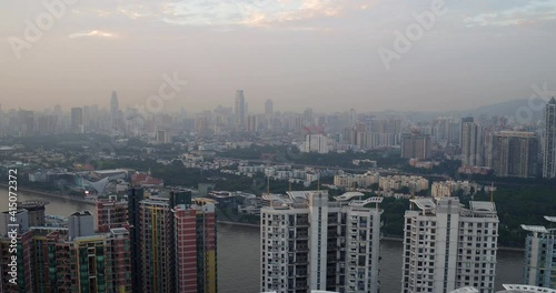 View of Guangzhou living blocks by the river side and far in the distance in late afternoon. Guangdong, China. photo