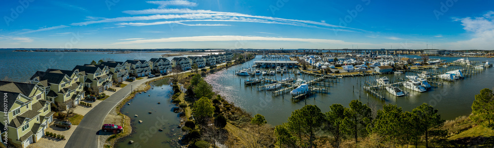 Aerial sunny winter view of luxury duplex residential neighborhood on a manmade promontory with luxury sail boats docked in the marina at Kent Island Narrows Maryland USA