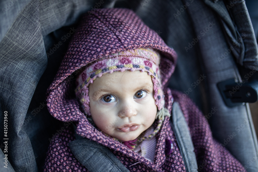 Adorable and curious baby wearing a wool hat in stroller Adorable and curious baby wearing a wool hat in stroller