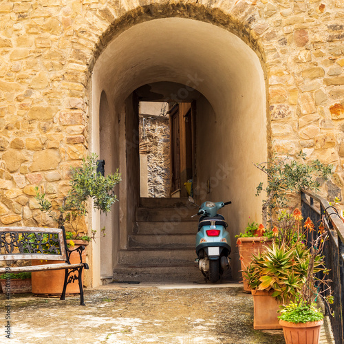 Italy, Sicily, Messina Province, Caronia. A scooter parked in an arched pathway in the medieval town of Caronia.