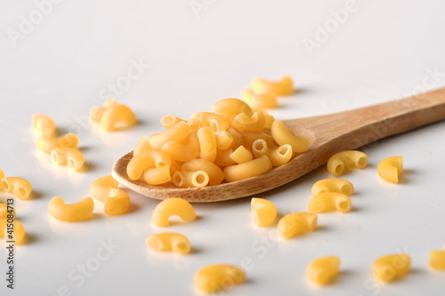 uncooked elbow macaroni on a white background. 