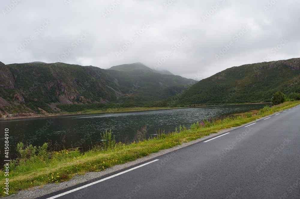 road in the mountains with fjord and clouds