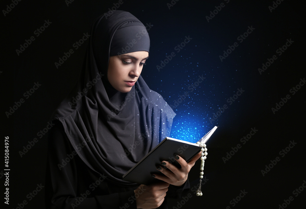 Muslim woman with Koran and tasbih on dark background Muslim woman with Koran and tasbih on dark background
