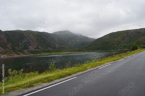 road in the mountains with fjord and clouds