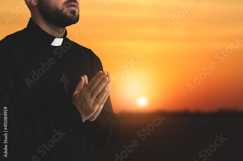 Young priest praying to God...