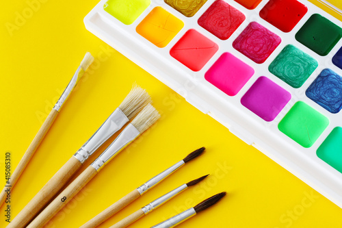 paint brushes and bright water colours palette