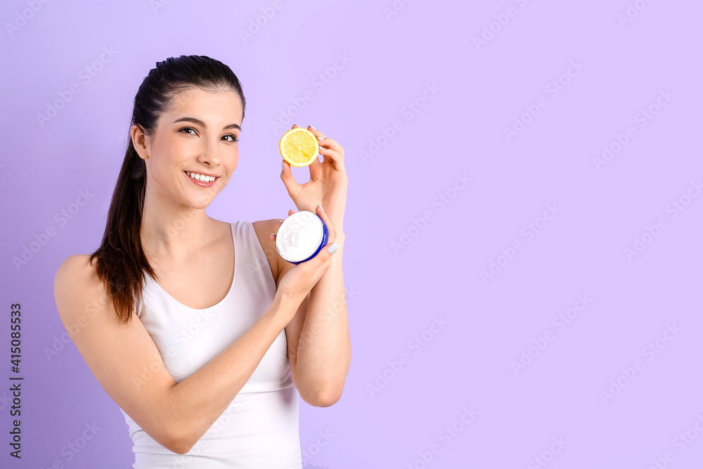 Beautiful young woman with facial cream and lemon on color background Beautiful young woman with facial cream and lemon on color background