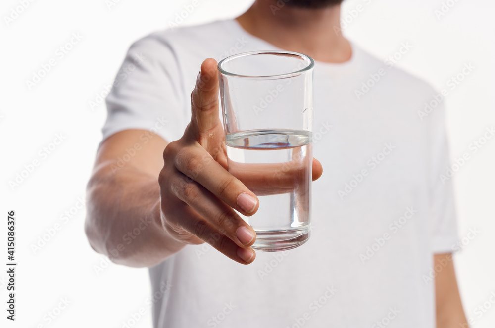 a glass of clean water in the hand of a man in a light shirt cropped view a glass of clean water in the hand of a man in a light shirt cropped view