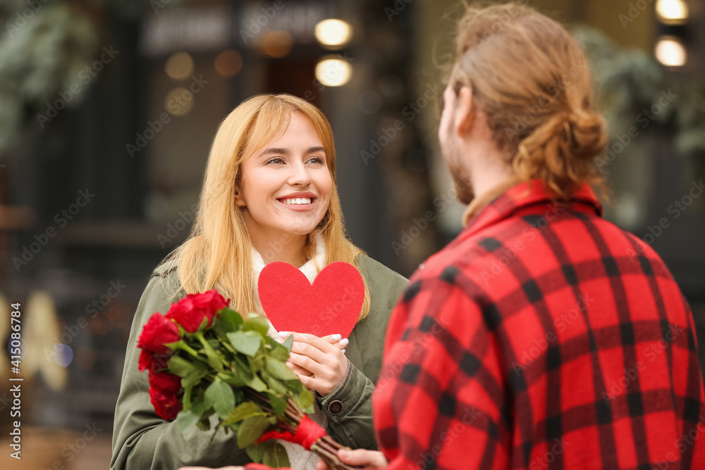 Happy young couple walking in city on Valentine's Day
