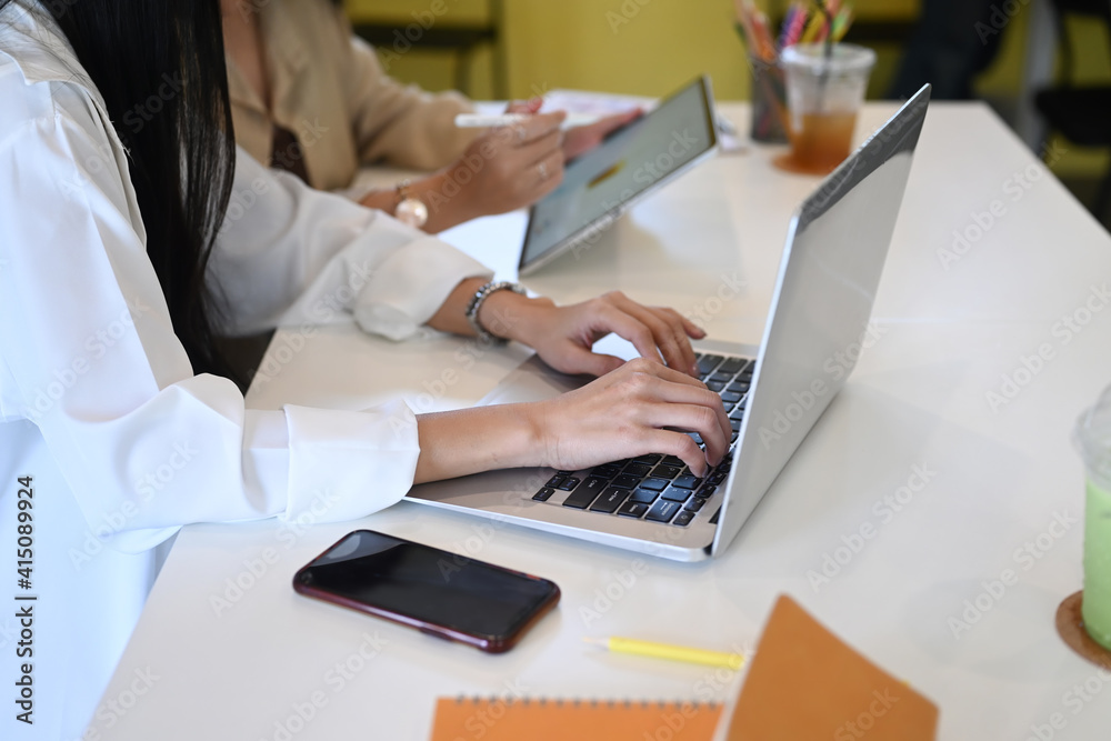 Two businesswoman working with modern devices and planning marketing in office. Two businesswoman working with modern devices and planning marketing in office.