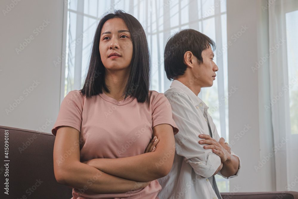 Unhappy young asian couple fights on couch, relationship is in trouble. Different people are angry and use emotions at each other. Wife has an expression of disappointment and upset with her husband. Unhappy young asian couple fights on couch, relationship is in trouble. Different people are angry and use emotions at each other. Wife has an expression of disappointment and upset with her husband.