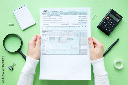 A man holds a 1040 tax form in his hands. Usa taxation concept. 1040 Individual Income Tax Return 