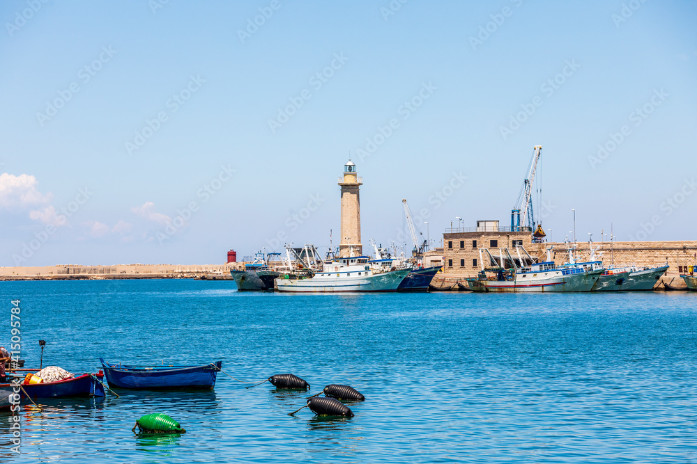 Italy, Apulia, Metropolitan City of Bari, Molfetta. Fishing boats and lighthouse.