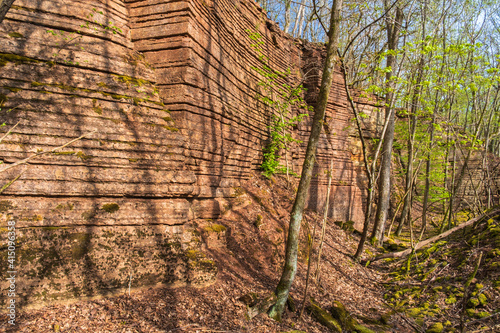 Rock face in an old quarry with lush trees in spring photo