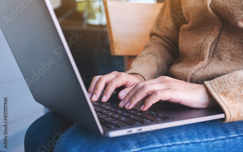 Closeup image of a woman working and typing on laptop computer keyboard