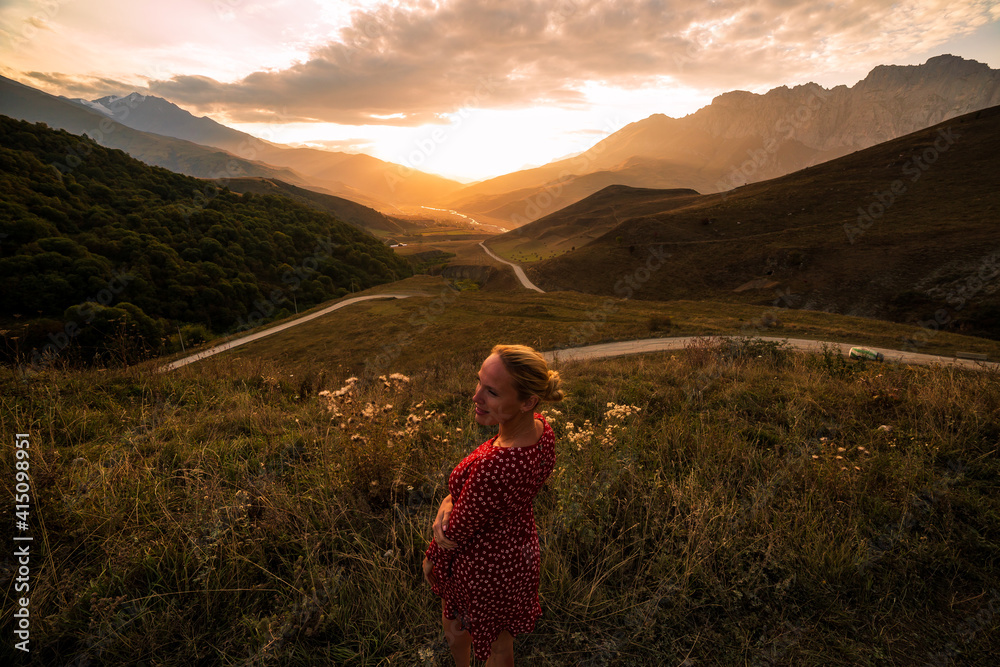 Blonde model at the sunset in mountains