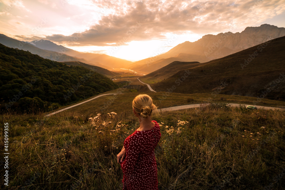 Blonde model at the sunset in mountains