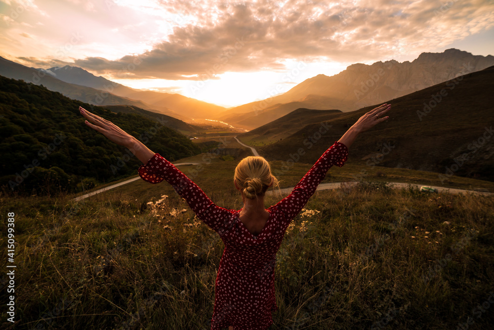 Blonde model at the sunset in mountains