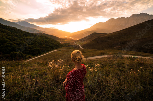Blonde model at the sunset in mountains 