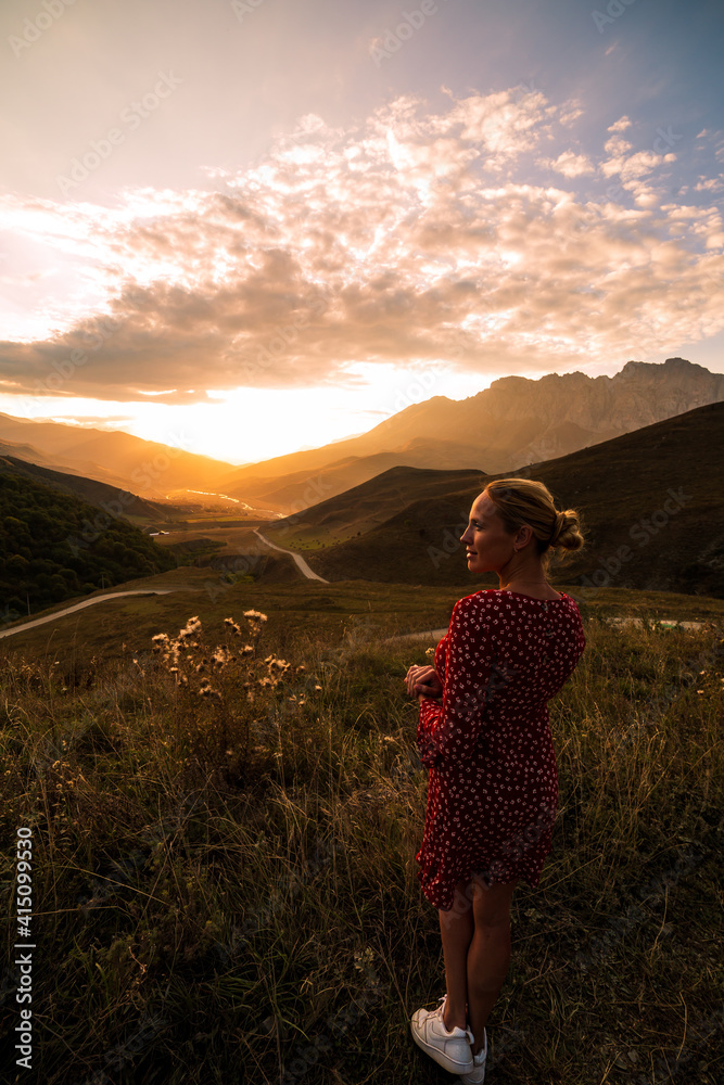 Blonde model at the sunset in mountains