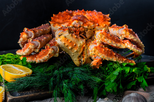 Tasty king kamchatka crab with lemon slices on wood board