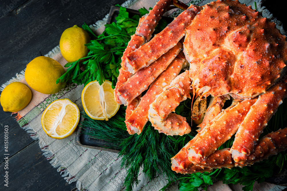 Tasty king kamchatka crab with lemon slices on wood board Tasty king kamchatka crab with lemon slices on wood board