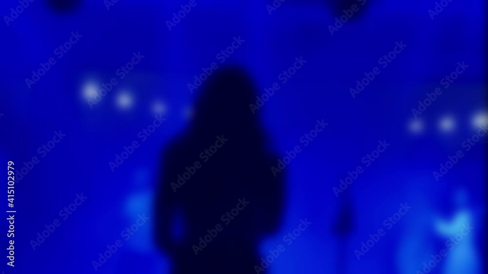 Rear view of a girl singing to microphone on blurred background. Unrecognisable person pop singer on concert night party club. Party concept, have fun tonight. Slow motion video. Rear view of a girl singing to microphone on blurred background. Unrecognisable person pop singer on concert night party club. Party concept, have fun tonight. Slow motion video.