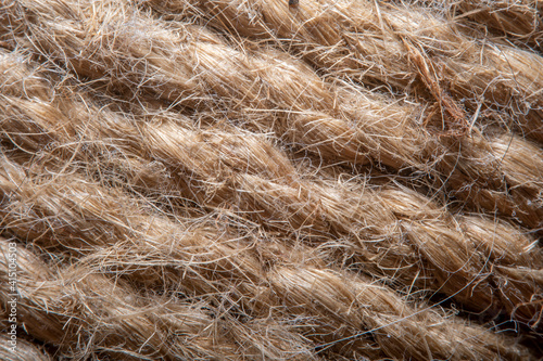 A background of roughly knitted fabric in soft focus under high magnification. Synthetic fabric stylized as an old, chunky-knit linen thread.