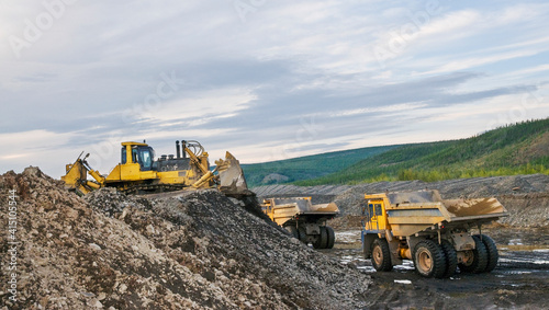 Mining dump trucks, WHEEL LOADERS AND Bulldozer in operation in an industrial mining area