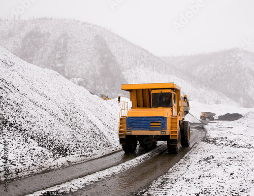 A mining dump truck in an industrial mountainous area in the process. Mining