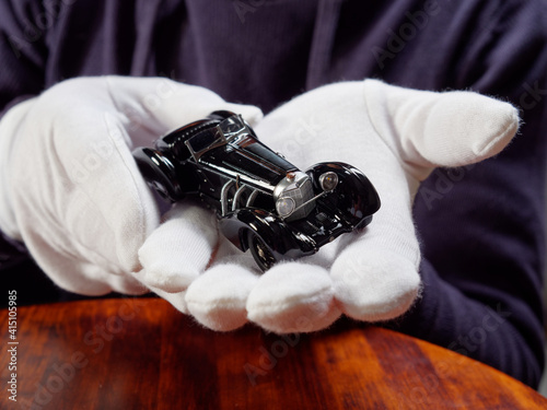 GOMEL, BELARUS - February 16, 2021: portrait of a collector of retro car models on a black background photo