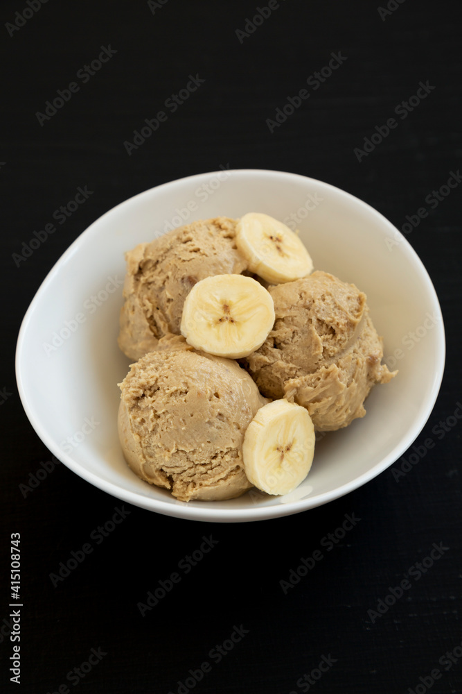 Homemade Peanut Butter Banana Ice Cream in a Bowl on a black background, side view. Homemade Peanut Butter Banana Ice Cream in a Bowl on a black background, side view.