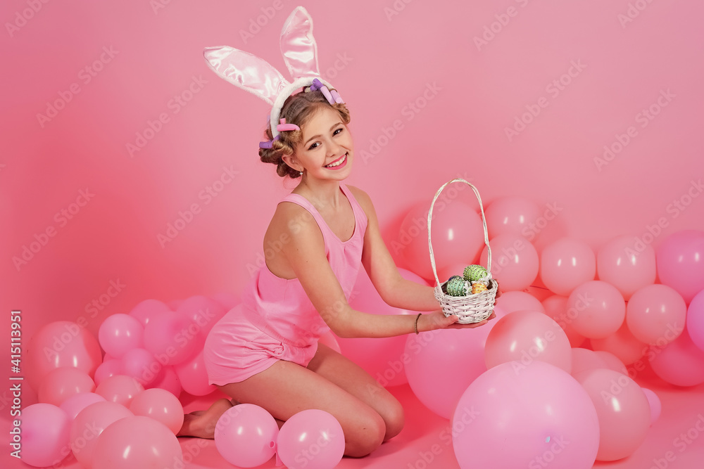 Teenager girl paint eggs. Easter little girl in bunny ears. Happy easter, child in pink studio.