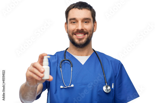 healthcare, profession and medicine concept - happy smiling doctor or male nurse in blue uniform with oral spray and stethoscope over white background